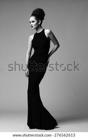 high fashion portrait of elegant woman in long black dress. Black and white studio shot