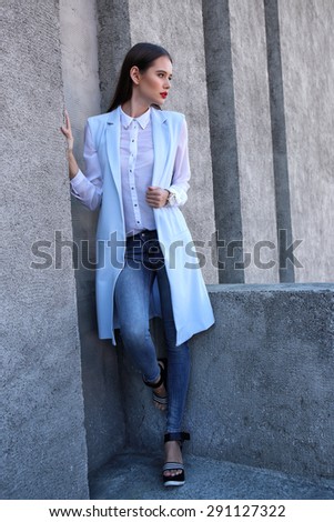 high fashion portrait of young elegant woman outdoor in blue jacket, blouse, jeans.