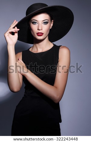 high fashion portrait of elegant woman in black hat and dress. Studio shot, vintage fashion