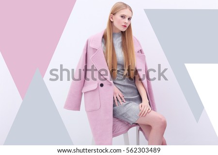 Young elegant woman in trendy pink coat. Blond hair, silver dress, isolated studio shot.