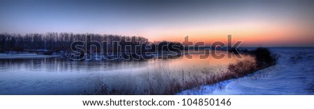 Sunrise panoramic HDR view of the river Jiu and its frozen valley on the day of winter solstice (shortest day of the year, Romania, Dolj County).