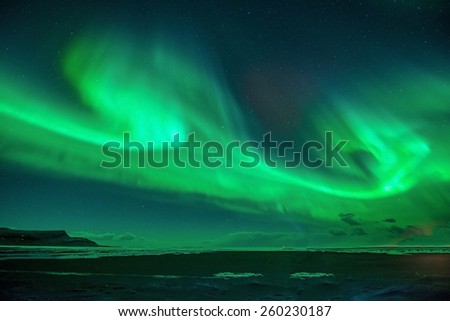 A beautiful green  aurora dancing over the Jokulsarlon lagoon, Iceland. northern lights over plane wreck  in Iceland.Contains Noise.