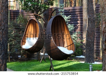Round modern furniture plastic wicker chairs in garden