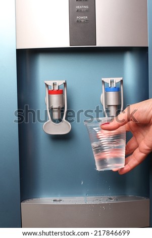 filling cup at water cooler, water dispenser