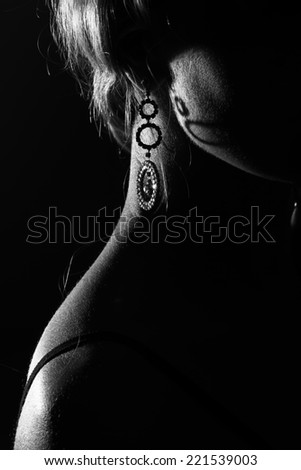 Art photo of beautifull woman neck and ear with earring, dark photo. Artistic black and white photo