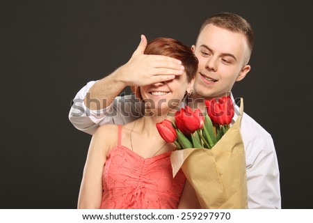 Man surprising his girlfriend with flowers, emotions, red flowers