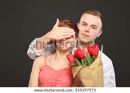 Man surprising his girlfriend with flowers, emotions, red flowers