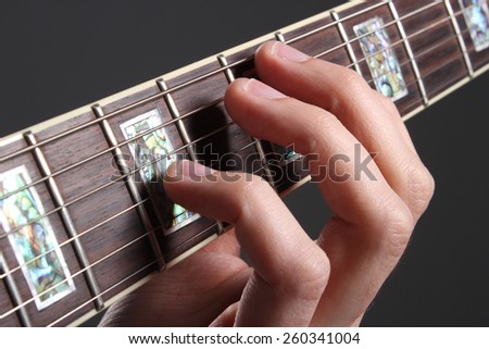 Human hand playing guitar, fingers