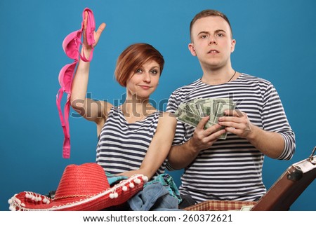 happy couple is going on a trip, pack a suitcase. Woman with bra, man with money