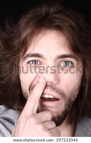 handsome man with a beard, finger in the nose, fun