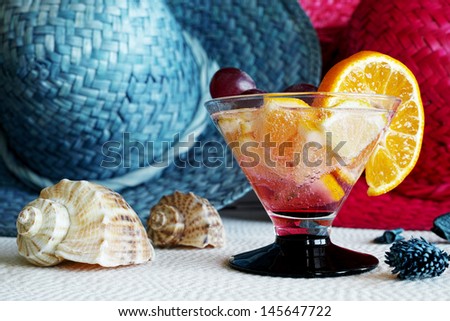 Carbonated drink glass with an orange slice on the straw hat background