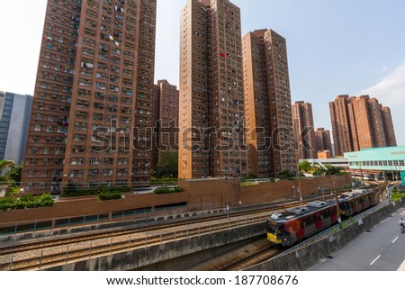 HONG KONG, CHINA - APR 12, 2014: Fast moving light rail approaching Siu Hong station in Hong Kong  Siu Hong Court apartment complex can be seen in the background