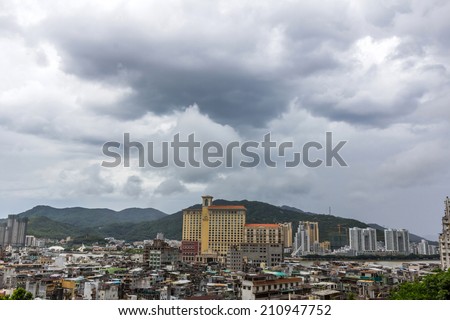 MACAU - JUNE 6, 2014: Macau packed houses and city skyline under the cloudy sky. Rich and poor stays close to each other in Macau, China.