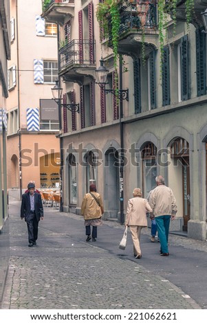 LUCERNE, SWITZERLAND - SEP 16, 2014: Old people walking along the streets. Due to its location on the shore of Lake Lucerne within sight of Swiss Alps, Lucerne has long been a destination for tourists