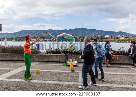 ZURICH, SWITZERLAND - SEP 21, 2014: A person entertain the crowd gathered at lake of Zurich. Outdoor entertainment is the part of European culture.