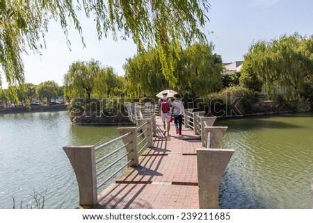 SHANGHAI, CHINA - OCT 24, 2014: A couple walking on a bridge in the Shanghai Jiao Tong University (SJTU). SJTU is renowned as one of the oldest and most prestigious universities in China.