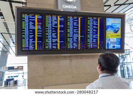 HONG KONG - APR 30, 2015: A person check the flight timetable in departure terminal of Hong Kong International Airport. About 90 airlines operate flights from HKIA to over 150 cities across globe.
