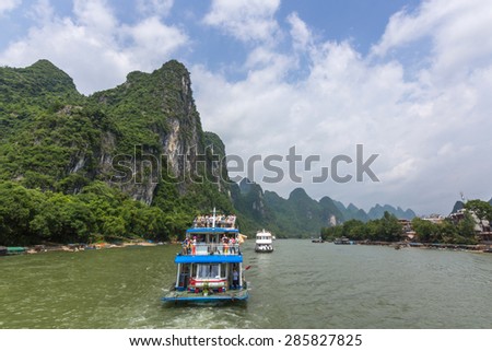 YANGSHUO, CHINA - MAY 01, 2015: Cruise ship packed with tourists travels the magnificent scenic route along the Lijiang river from Guilin to Yangshou.