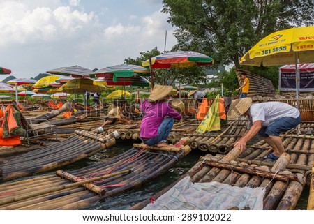 GUILIN, CHINA - MAY 02, 2015: A port for traditional bamboo rafts in a bank of Yulong River in Yangshuo China. Yulong river is famous among tourists due to surrounded landscape of limestone karst.