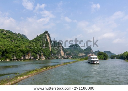 Cruise ship packed with tourists travels the magnificent scenic route along the Li river from Guilin to Yangshou.