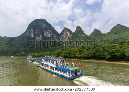 GUILIN, CHINA - MAY 02, 2015: Cruise ship packed with tourists travels the magnificent scenic route along the Li river from Guilin to Yangshou.