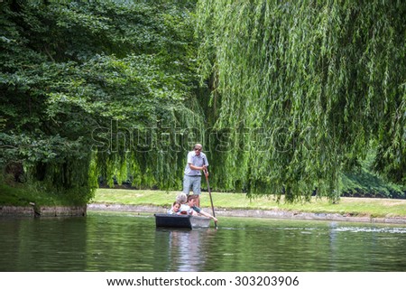 CAMBRIDGE, UK - JULY 22, 2015: Punting in summer on the river Cam. There are several companies on the Cam operating tours and hiring punts to visitors.
