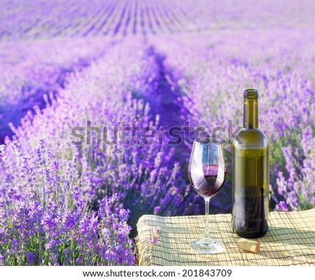 Bottle of wine against lavender landscape.