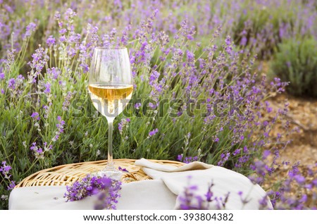 Wine glass against lavender landscape.
