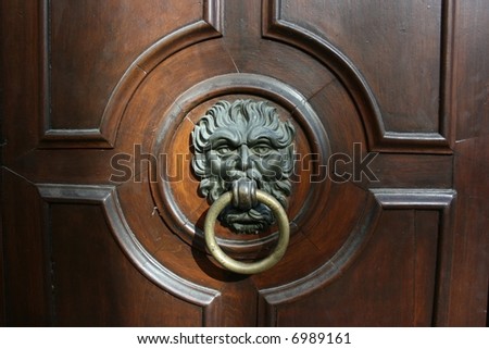 Impressive iron door knocker on a massive wooden door