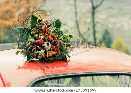 Autumnal bouquet on the top of retro car. The noise is added for art purposes