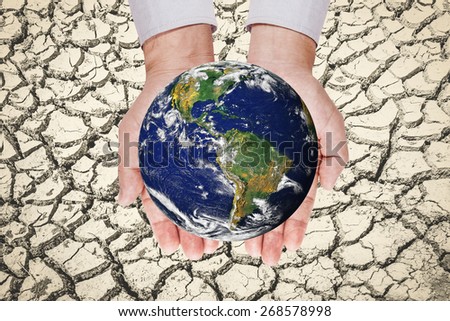 world ball in the hand on the soil cracked.Elements of this image furnished by NASA