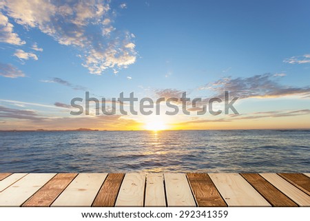 wood bridge with the ocean and beautiful sunset sky,Sun is in the middle frame