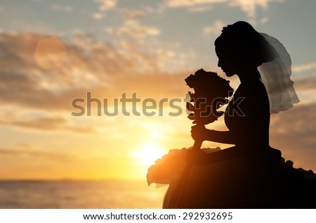 Silhouette of a bride holding a bouquet of rose in loneliness