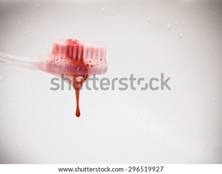 scurvy in a bubble toothpaste on the toothbrush on the white background. Blood on the toothbrush.Copy space on frame