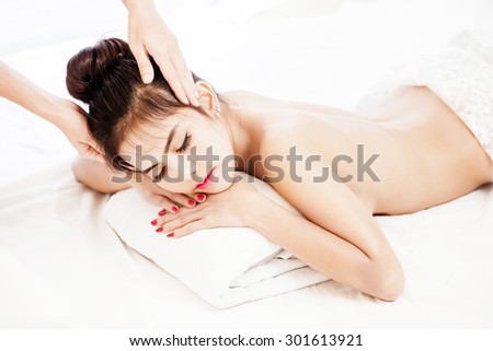 Beautiful Asian woman receiving spa massage. Focus on the model face. Macro with extremely shallow dof.