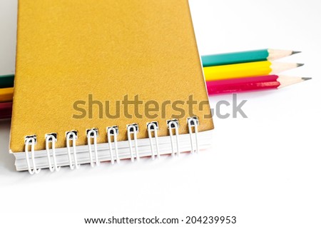 Pencil and notebook on white background , stationery ,Colored pencils, red, blue, green , Notebook yellow