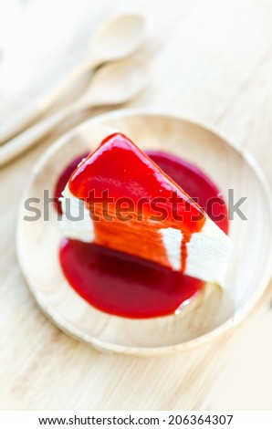 Cake topped with strawberry sauce , Cake strawberry sauce shallow depth , Cake shallow depth, with wooden Dish and Spoon