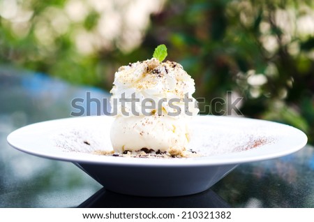 Ice Cream with whipped Cream on dish and green bokeh , Whipped ice cream on plate