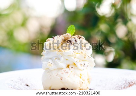 Ice Cream with whipped Cream on dish and green bokeh , Whipped ice cream on plate
