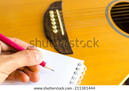 Notebook and pencil on guitar, Writing music , Write a Song