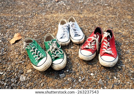 Red , green , blue Sneakers shoes walking on gravel road , Canvas shoes walking on gravel road , two sneakers behind each others as a sign of love , Sneakers shoes Couple