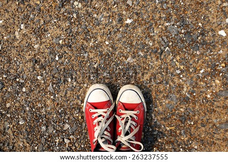 Red  Sneakers shoes walking on gravel road , Canvas shoes walking on gravel road