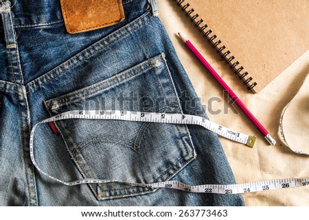 measuring tools and jeans denim , still life jeans  ,red pencil , notebook , measure tape