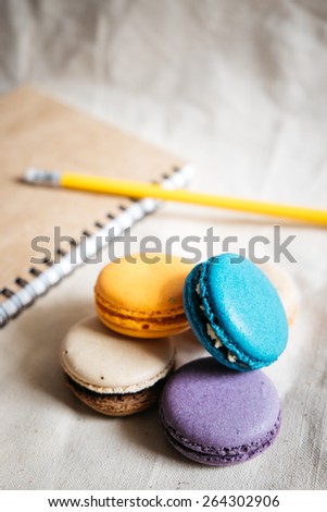 Macaron colorful pastel with stationery on fabric , Macaron colorful pastel with Notebook, pencil on fabric