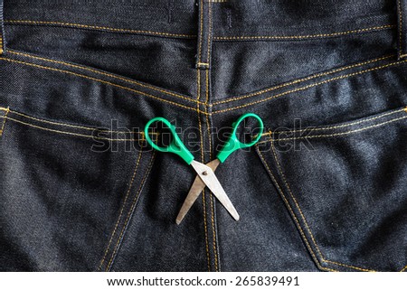 green scissors on jeans