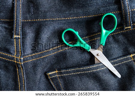 green scissors in jeans pocket