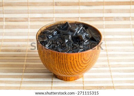 Grass jelly (choa kuay)  with crushed ice in wood cup on wooden plate for Thirst time