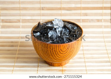 Grass jelly (choa kuay)  with crushed ice in wood cup on wooden plate for Thirst time