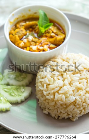 Red curry with pork and rice (Panaeng) on dish and on wooden, Thai food ,top view