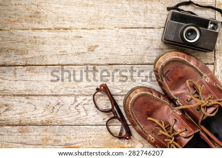 Camera and glasses and Leather shoe on a wooden , Still life travel on wooden